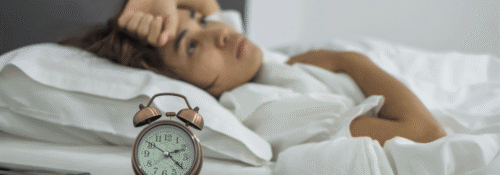 Woman lying awake in bed struggling with insomnia